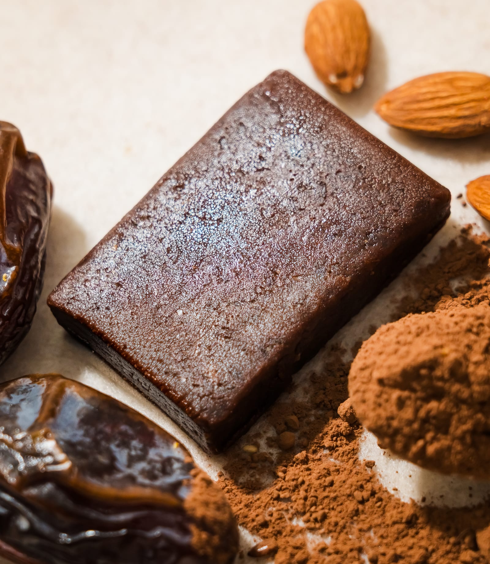 Barrita Delinuts Original con dátiles, almendras y cacao en polvo alrededor